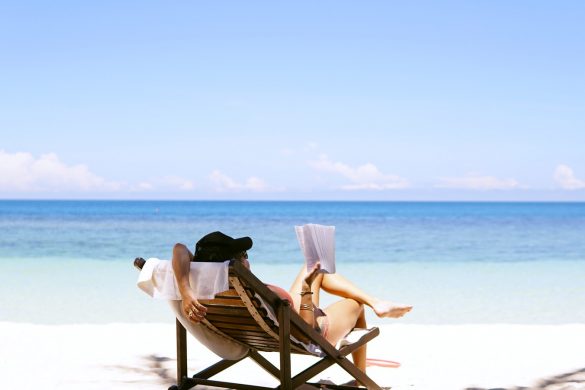 woman sits on brown wooden beach chair