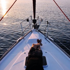 man lying on white boat